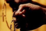 Una mujer sujeta un Rosario