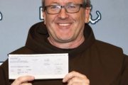 El padre Thomas Conway del santuario de San Antonio de Boston al cobrar el boleto de lotería