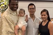 Tan Le junto a su familia y el sacerdote que le acompañó en su proceso de conversión y que se culminó con su bautismo y el de su hijo menor