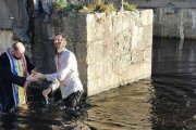 Un sacerdote ortodoxo rumano bautiza en un río irlandés al escrito inglés Paul Kingsnorth en 2021