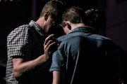 Unos hombres oran por un joven - todos los cristianos pueden hacer oración de intercesión - foto Jack Sharp