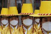 Coreanos con traje típico y mascarillas contra el coronavirus