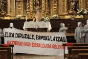 Irrumpieron en la parroquia con los rostros ocultos tras caretas blancas y vestidos con buzos, desplegaron una pancarta en la que acusaban a la Iglesia de avariciosa y especuladora.