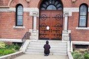 Una mujer reza ante la parroquia de Santa Teresa de Calcuta, en Dorchester, Boston, EEUU, cerrada por la pandemia, en 2020
