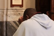 Sacerdote rezando arrodillado.