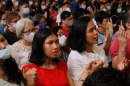 Filipinos en misa rezan con las manos levantadas el Padrenuestro