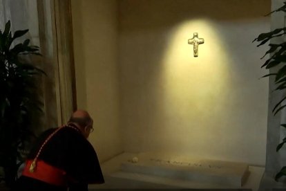 Un cardenal reza ante la tumba de Francisco, con su nombre y una rosa blanca depositada encima.