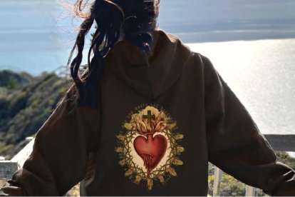 Una joven con una sudadera con el Sagrado Corazón, un símbolo potente en la cultura popular católica