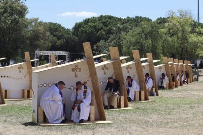 Un sacerdote escucha a otro en confesión en el Parque del Perdón de la JMJ de Lisboa 2023