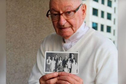 El padre William Creed (1927-2020), en 2013 mostrando una foto con sus padres y los ocho hermanos, todos sacerdotes, religiosos y religiosas.