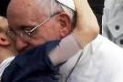 Francisco abraza a un niño
