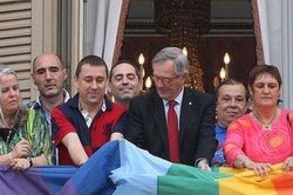 El alcalde de Barcelona, Xavier Trias, de CiU, despliega una bandera gay en el balcón del Ayuntamiento, con líderes del lobby gay de Cataluña