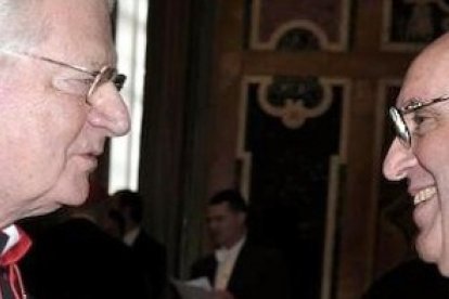 El cardenal Scola conversa con el Papa Francisco.