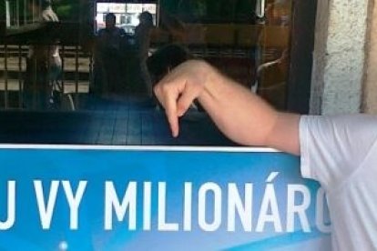 Denis Blaho, hoy profesor de inglés, señala un anuncio de loteria del Euromillón - con la fe, él se sabe ganador