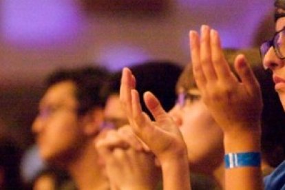 Una chica en oración en un encuentro de los grupos católicos de adolescentes LifeTeen