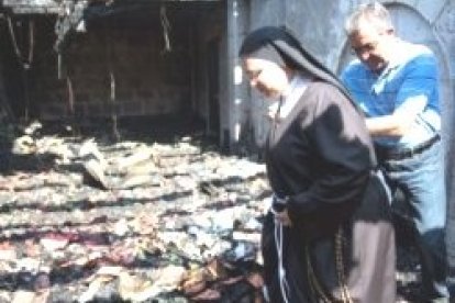 Una religiosa examina la zona destruida en los benedictinos de Tabga por el incendio provocado por extremistas