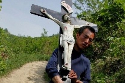 Un peregrino católico con un crucifijo en la provincia china de Shaanxi