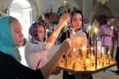 Jóvenes ortodoxas ponen velas en su iglesia - un 30 por ciento de los rusos siente la cercanía de Dios en su vida