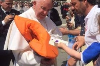 Francisco contempla el salvavidas de una niña ahogada en Lesbos que le llevó una ONG de socorristas