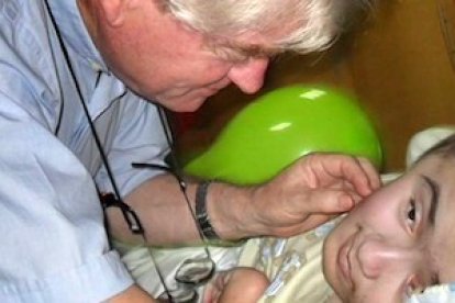 Aldo Trento, junto a un niño con hidrocefalia atendido en uno de sus centros.
