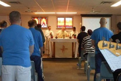 El arzobispo Miller de Vancouver celebrando misa en la cárcel en presencia de los reclusos