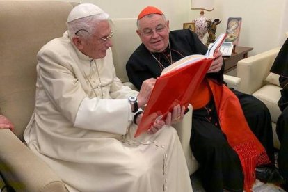El cardenal Dominik Duka, arzobispo de Praga (República Checa), obsequia un libro a Benedicto XVI durante la visita que le hizo en noviembre pasado. Foto: Vatican News.