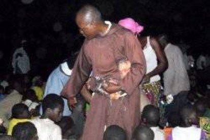 Un franciscano entre niños de Benín, país muy pobre de fuerte cultura vudú donde es común el pensamiento de que los espíritus requieren sacrificios