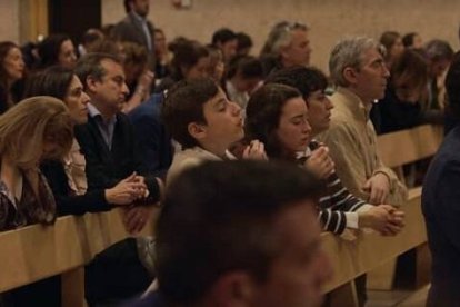 Gente en adoración eucarística en el documental de testimonios Vivo