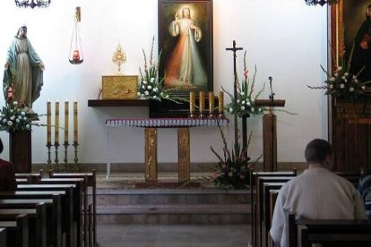 Oración ante el icono de la Divina Misericordia y un retrato de Santa Faustina Kowalska