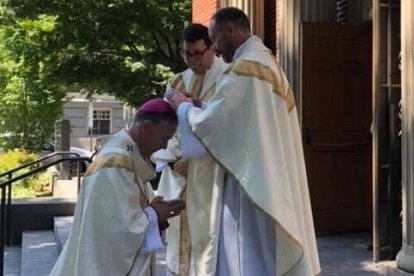 Brent Crowe bendice al arzobispo Sample en 2018, tras ser ordenado sacerdote