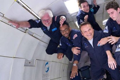 El diácono Gary Nosacek -pelo blanco, a la izquierda- flotando en gravedad cero