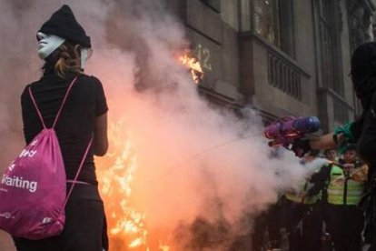 Incendio provocado en una marcha de feministas abortistas en México  - unas encapuchadas echan un chorrito de agua, quizá arrepentidas