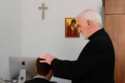 El padre Mcdonagh, exorcista del Patriarcado Latino de Jerusalén, impone las manos a un joven