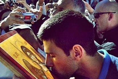 En la imagen, Novak Djokovic, fiel de la Iglesia ortodoxa serbia, besa un icono.