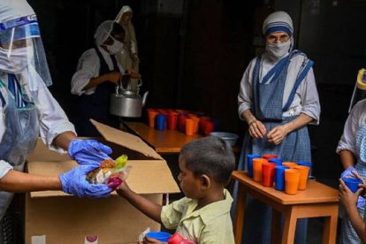 Una Misionera de la Caridad entregando comida a un niño en la India