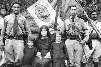 Familia cristera junto a la bandera mexicana y guadalupana, prestos al combate por Cristo Rey.