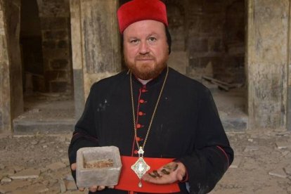 Sharaf, obispo siro-ortodoxo de Mosul, muestra los recipientes de piedra y las reliquias guardadas dentro en la destrozada iglesia de Santo Tomás