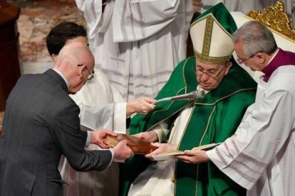 Francisco entrega la Biblia a una de las personas a las que confirió este domingo el ministerio de lector. Foto: Vatican Media.