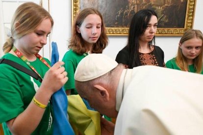 Francisco besa una bandera ucraniana al recibir 15 peregrinos ucranianos en la Nunciatura de Lisboa