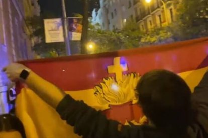 Un joven manifestante de las protestas de Ferraz, con una bandera del Sagrado Corazón de Jesús.