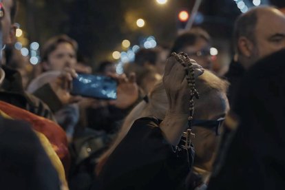 En la imagen, una mujer sostiene el Rosario durante las concentraciones ante la sede socialista de la calle Ferraz de Madrid.