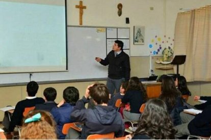 Una clase en una escuela católica, con crucifijo y una imagen de la Virgen