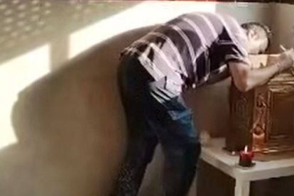 Fabián besa el sagrario que salvó poniendo en riesgo su vida. Captura El Rosario de las 11 p.m.