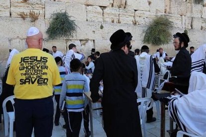 El hombre de la camiseta amarilla lleva un mensaje cristiano, Jesús como puerta a la salvación, en el Muro de las Lamentaciones de Jerusalén