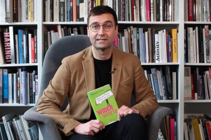 Alexander Kissler, delante de una librería llena de libros.
