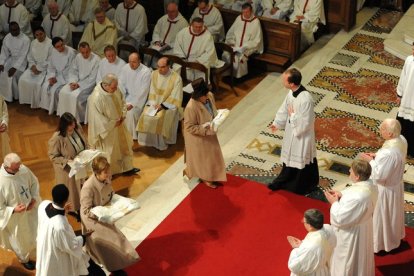 Las esposas de los tres antiguos obispos anglicanos Broadhurst, Newton y Burnham avanzan con los ropajes sacerdotales en la ordenación católica de ellos en 2011