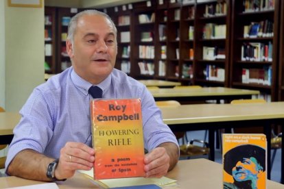 Emilio Domínguez Díaz muestra un libro de Roy Campbell.