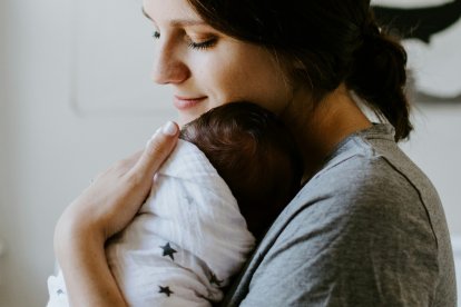 Una mamá abraza a su bebé, muy pequeño