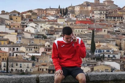 Un joven piensa con fondo de la ciudad de Toledo.