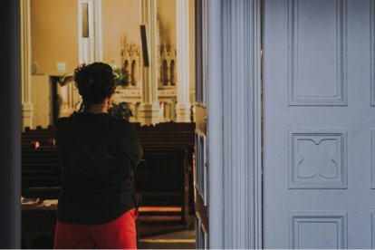 Una mujer a la entrada de una capilla, quizá orando sin entrar